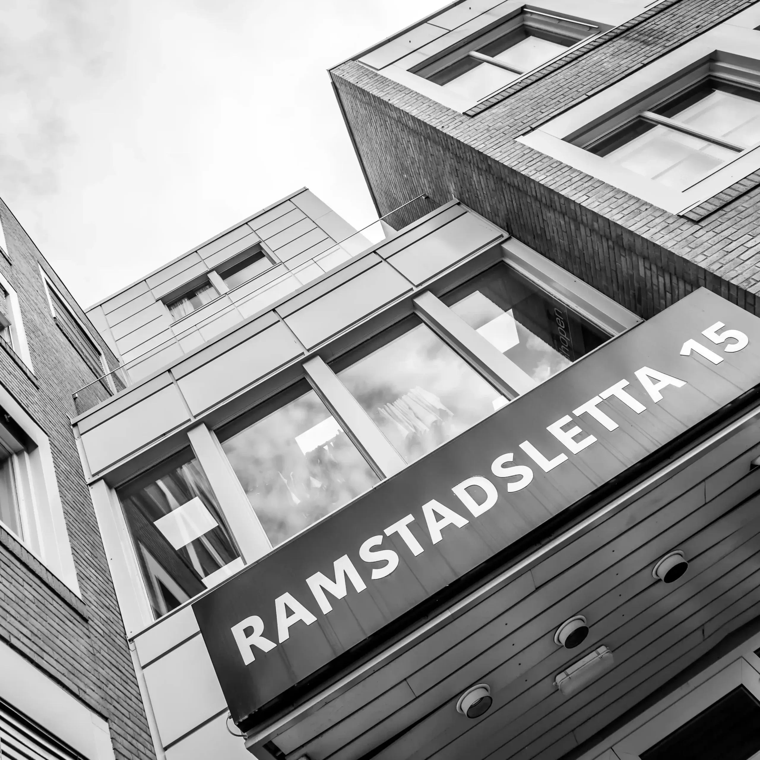 Næringsbygg i svart-hvitt med skiltet Ramstadsletta 15